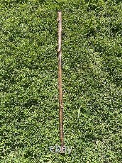 Vintage wooden walking stick with leather strips and decirations