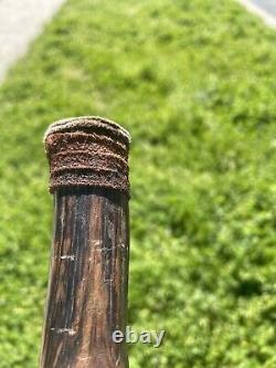 Vintage wooden walking stick with leather strips and decirations