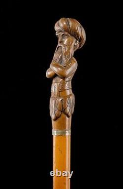 WALKING STICK WITH FIGURATiv Wooden grip, carved as a man wearin